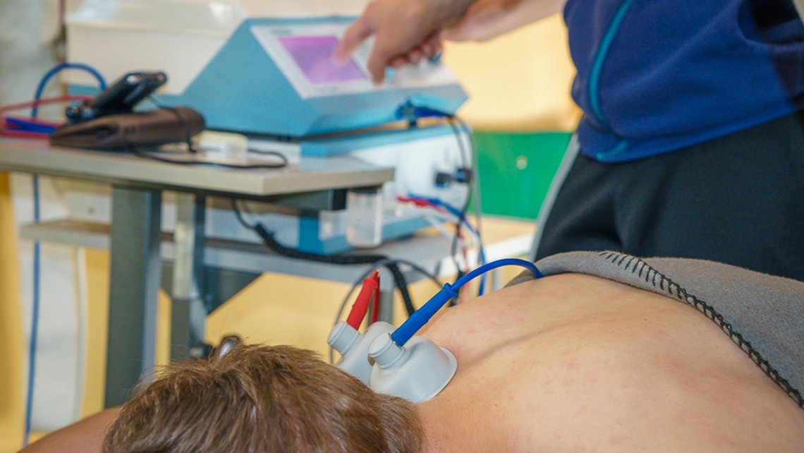 Anwendung von Elektrotherapie am Rücken