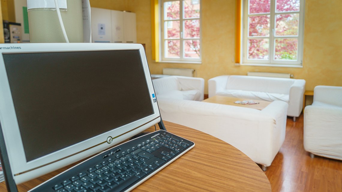 Innenraumeindruck mit Laptop und weißen Sofas in der Kybalion Einrichtung