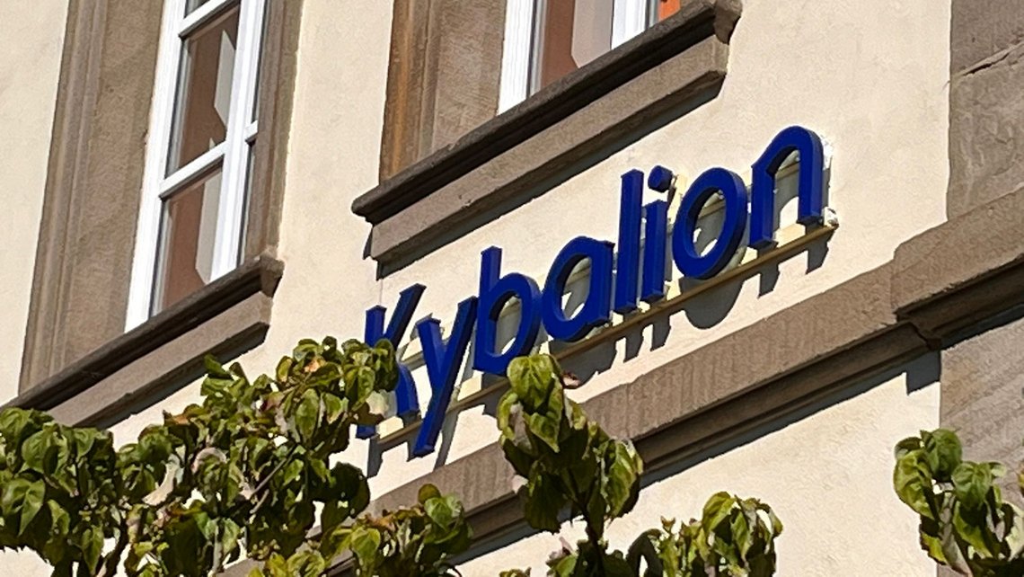 Kybalion Schriftzug an der Fassade des Schulgebäudes