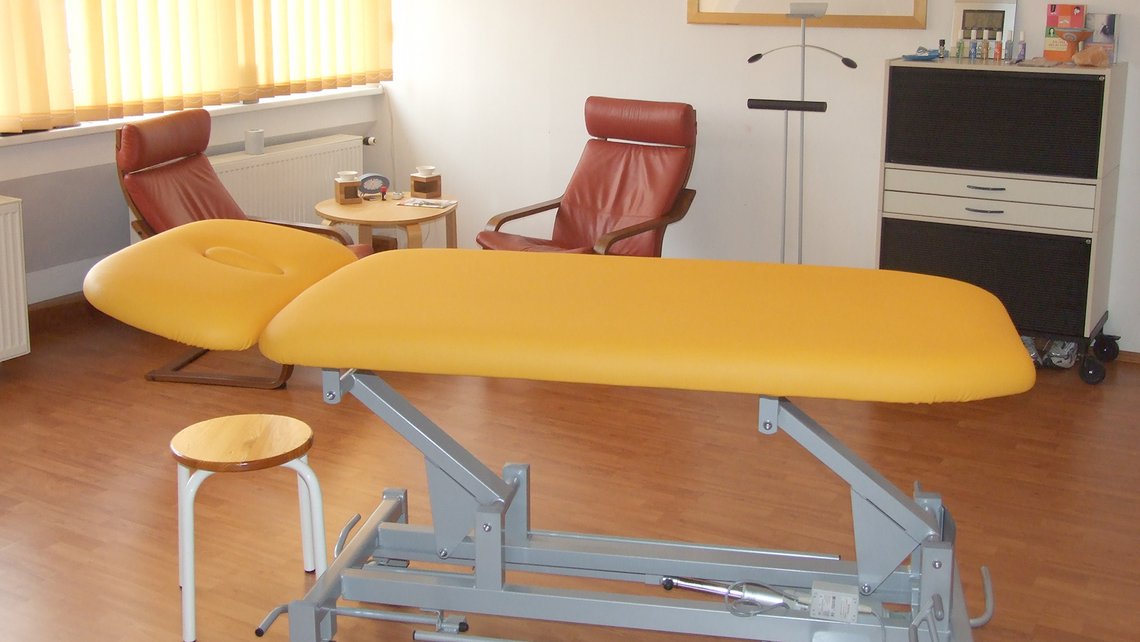 Behandlungsraum mit Therapieliege und Stuhl