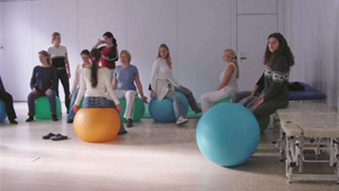 Gruppentraining im Unterricht, mit verschiedenen Fitnessgeräten und -hilfsmitteln