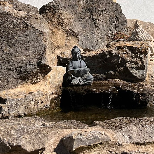Natursteinbrunnen mit Wasserlauf vor dem Gebäude
