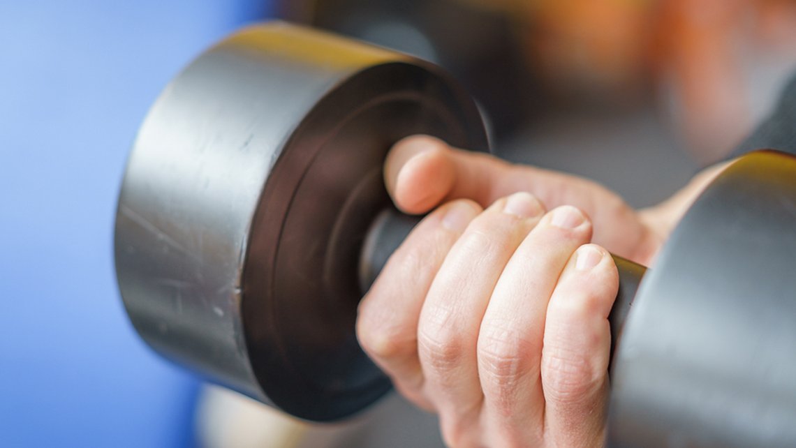 Hand hält Hantel im Trainingsraum der Kybalion Physiotherapie