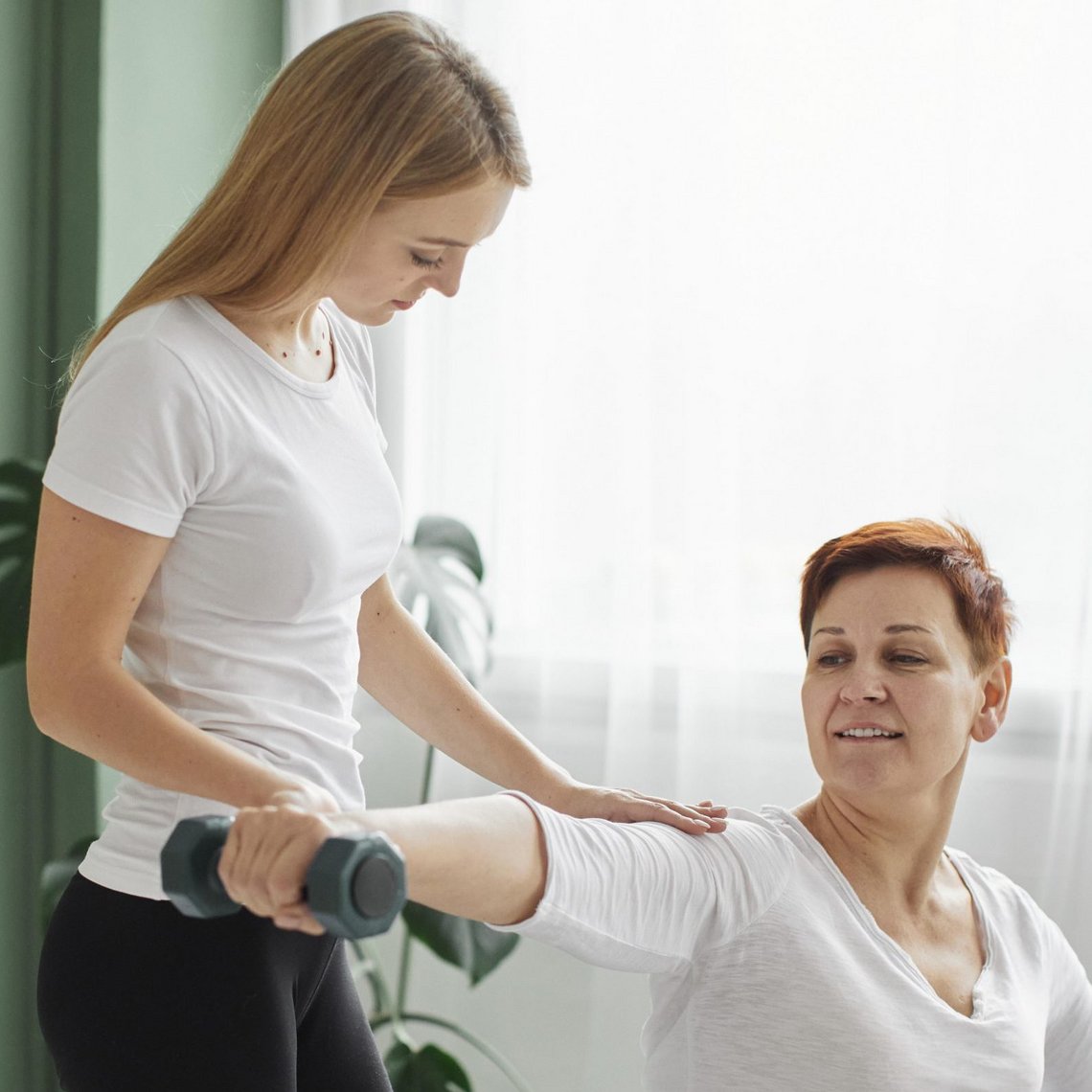 Physiotherapeutin erklärt Behandlungsschritte einem Patienten