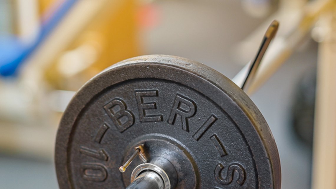 Nahaufnahme einer Gewichtsscheibe mit Schriftprägung im Kybalion Trainingsbereich
