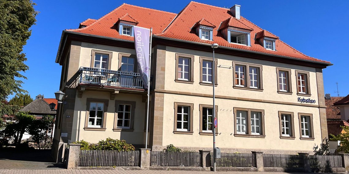 Vorderansicht des Kybalion Schulgebäudes mit rotem Dach und heller Fassade