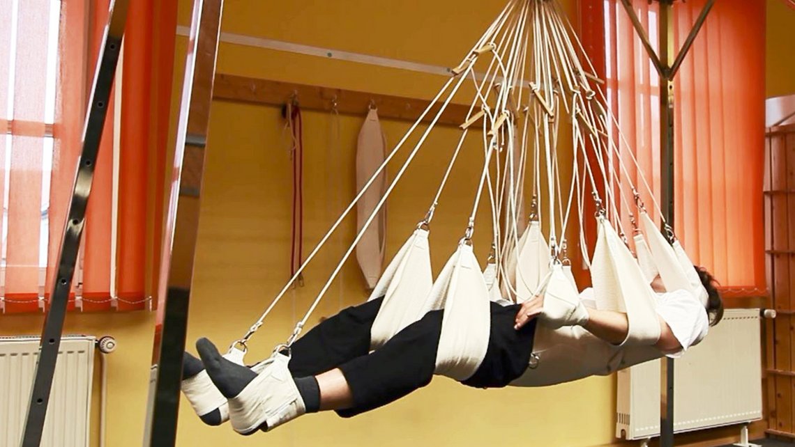 Schlingentisch, auf dem eine Person liegt und trainiert