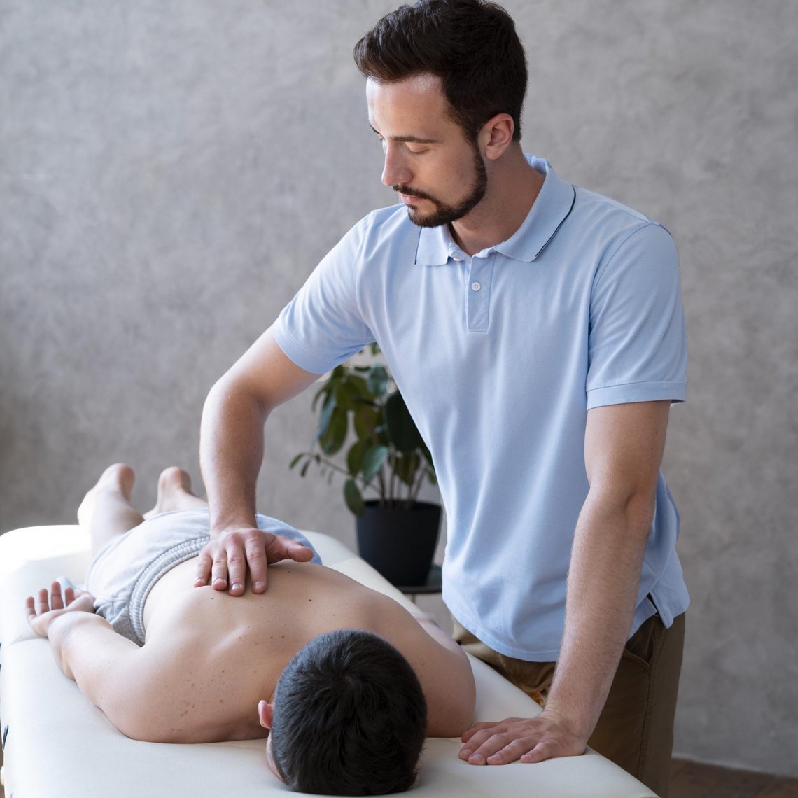 Therapeut führt manuelle Therapie an Patient auf Massageliege durch