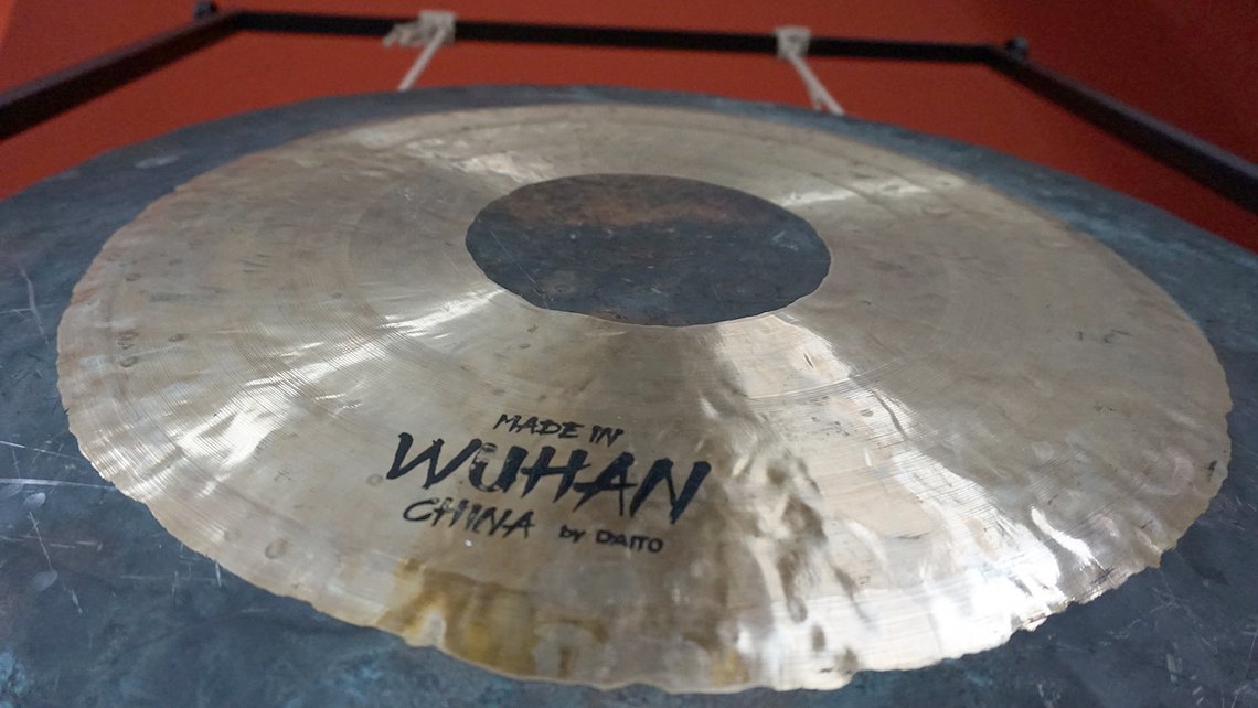 Gong aus Metall, mit Schlägel und reflektierendem Licht